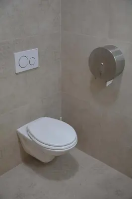 a bathroom with a toilet and a toilet paper dispenser at New City Centre Garden Apartment - Central Location in Prague