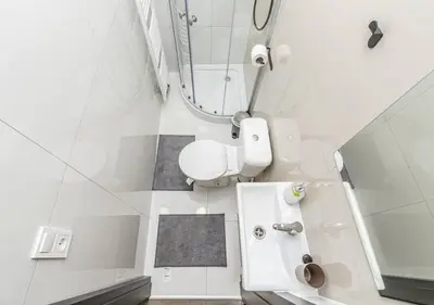 a white bathroom with a toilet and a mirror at Crimson Charm in Prague