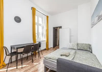a room with a bed and a table and chairs at Crimson Charm in Prague