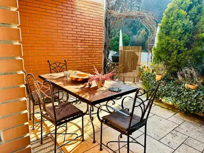 a wooden table with chairs on a patio at Nature Nest in Prague