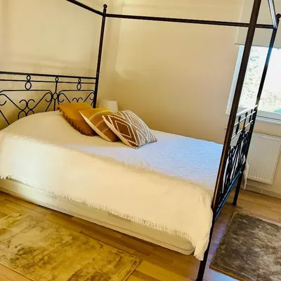 a bedroom with a black canopy bed with pillows at Nature Nest in Prague
