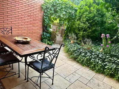 a wooden table and chairs sitting on a patio at Nature Nest in Prague