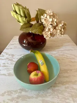 a bowl of fruit with a banana and apples on a table at Nature Nest in Prague