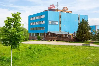 a blue building with a tree in front of it at Hotel CHODOV ASC in Prague