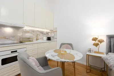 a kitchen with white cabinets and a table and chairs at Quiet and stylish apartment near Wenceslas Square in Prague