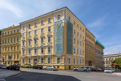 a large yellow building with cars parked in front of it at Quiet and stylish apartment near Wenceslas Square in Prague