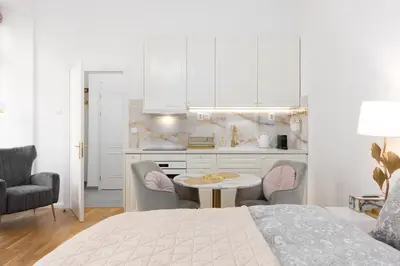 a bedroom with a bed and a table and a kitchen at Quiet and stylish apartment near Wenceslas Square in Prague