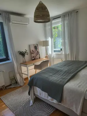 a bedroom with a bed and a desk and a window at Apartmán v Praze 6, Sedlec in Prague