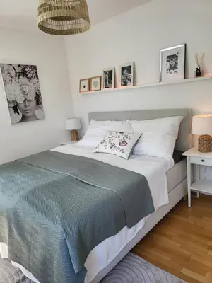 a bedroom with a large bed and a white wall at Apartmán v Praze 6, Sedlec in Prague