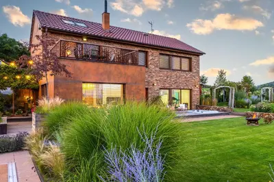 a brick house with a garden in front of it at Rezidence Malá Louka in Kublov