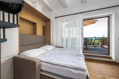 a bedroom with a bed and a large window at Rezidence Malá Louka in Kublov