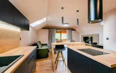 a kitchen with black cabinets and a kitchen island at Penzion U Mě in Obora