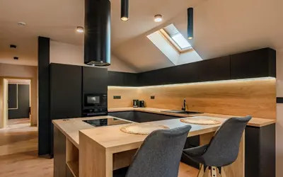 a kitchen with a island with chairs and a sink at Penzion U Mě in Obora