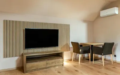 a living room with a tv and a table with chairs at Penzion U Mě in Obora