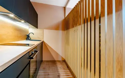 a staircase in a kitchen with wooden walls and a sink at Penzion U Mě in Obora