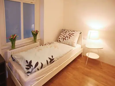 a small bed in a room with a window at Green Park View apartment in Prague