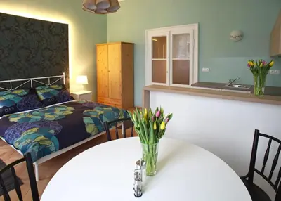 a bedroom with a bed and a table with flowers on it at Green Park View apartment in Prague