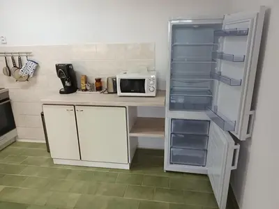 a kitchen with a refrigerator and a microwave at Byt v řadovém domě in Sadská