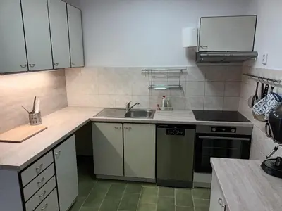a small kitchen with a sink and a stove at Byt v řadovém domě in Sadská