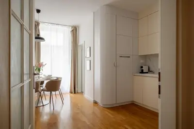 a kitchen with white cabinets and a stainless steel refrigerator at Urban Apartment Skorepka in Prague
