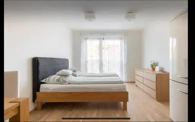 a white room with a bed and a window at Rezidence Garden Towers - studio s parkováním in Prague