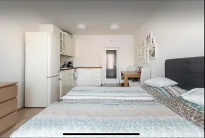 a white kitchen with a bed in a room at Rezidence Garden Towers - studio s parkováním in Prague