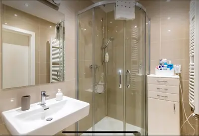 a bathroom with a glass shower and a sink at Rezidence Garden Towers - studio s parkováním in Prague
