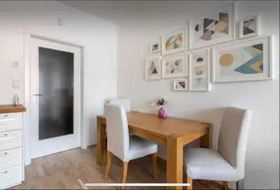 a dining room with a wooden table and chairs at Rezidence Garden Towers - studio s parkováním in Prague