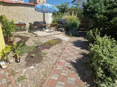 a garden with a patio with a table and an umbrella at Ubytování Louny in Louny