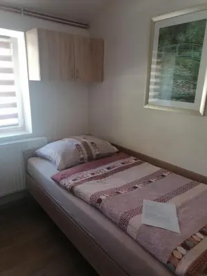 a small bedroom with a bed with a paper on it at Ubytování Louny in Louny