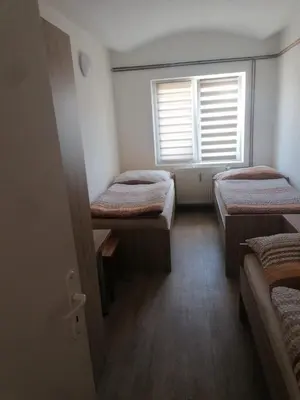 a room with three beds and a window at Ubytování Louny in Louny