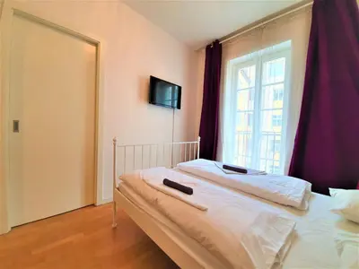 a bedroom with a large bed with a window at Apartment Sophia in Prague