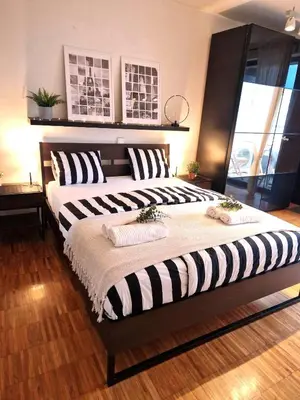 a bedroom with two beds with black and white pillows at Spacious Apartment near City Center with Balcony and Garage Parking in Prague