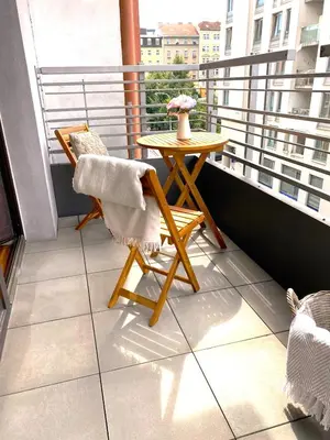 a balcony with a table and a chair on a balcony at Spacious Apartment near City Center with Balcony and Garage Parking in Prague