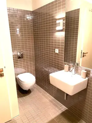 a bathroom with a white toilet and a sink at Spacious Apartment near City Center with Balcony and Garage Parking in Prague