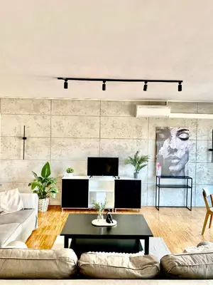 a living room with a couch and a table at Spacious Apartment near City Center with Balcony and Garage Parking in Prague