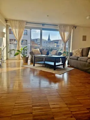 a living room with a couch and a table at Spacious Apartment near City Center with Balcony and Garage Parking in Prague
