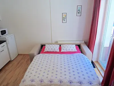 a bedroom with a bed with a red and white bedspread at Apartment Žižkov in Prague