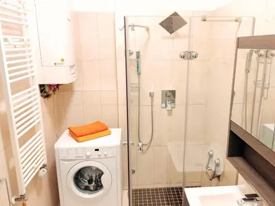 a small bathroom with a washing machine and a shower at Apartment Žižkov in Prague