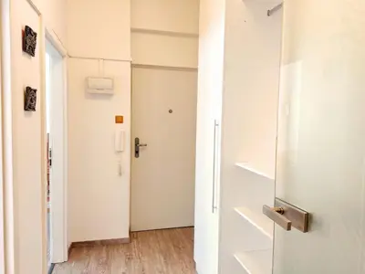 a hallway with a white door and a staircase at Apartment Žižkov in Prague