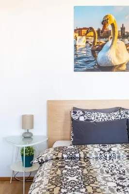 a bedroom with a bed and two swans in the water at Residence Vinohrad in Prague