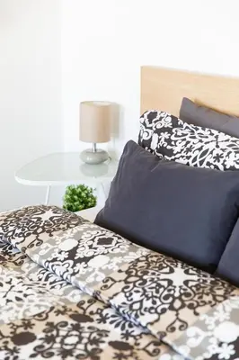 a bed with black and white sheets and a table at Residence Vinohrad in Prague
