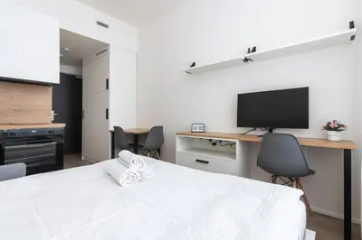 a bedroom with a bed and a desk with a television at Studio Mozart, Free Onsite Parking, Air Conditioning, 1Gbs WiFi in Prague