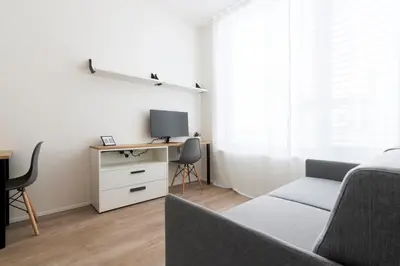a bedroom with a bed and a desk with a tv at Studio Mozart, Free Onsite Parking, Air Conditioning, 1Gbs WiFi in Prague
