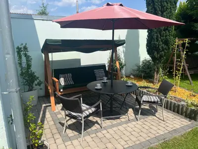 a table and chairs under an umbrella on a patio at Family House in Spa Town Podebrady with Garden in Poděbrady