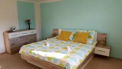 a bedroom with a wooden bed with yellow and blue pillows at Family House in Spa Town Podebrady with Garden in Poděbrady