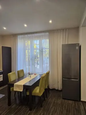 a dining room with a table and chairs and a refrigerator at Family House in Spa Town Podebrady with Garden in Poděbrady