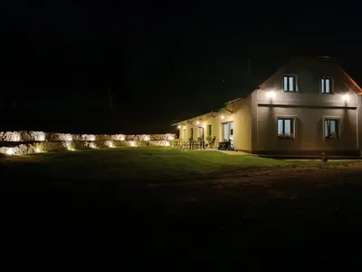 a house with lights on the side of it at night at Apartmán Pod Hrází Chráštany in Benešov