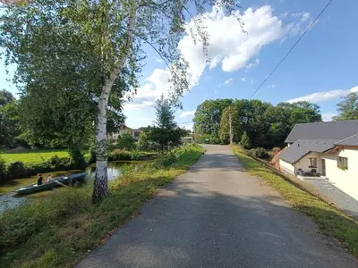 a road next to a river with a boat on it at Apartmán Pod Hrází Chráštany in Benešov