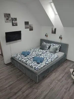 a bedroom with a large bed with blue pillows at Apartmán Pod Hrází Chráštany in Benešov